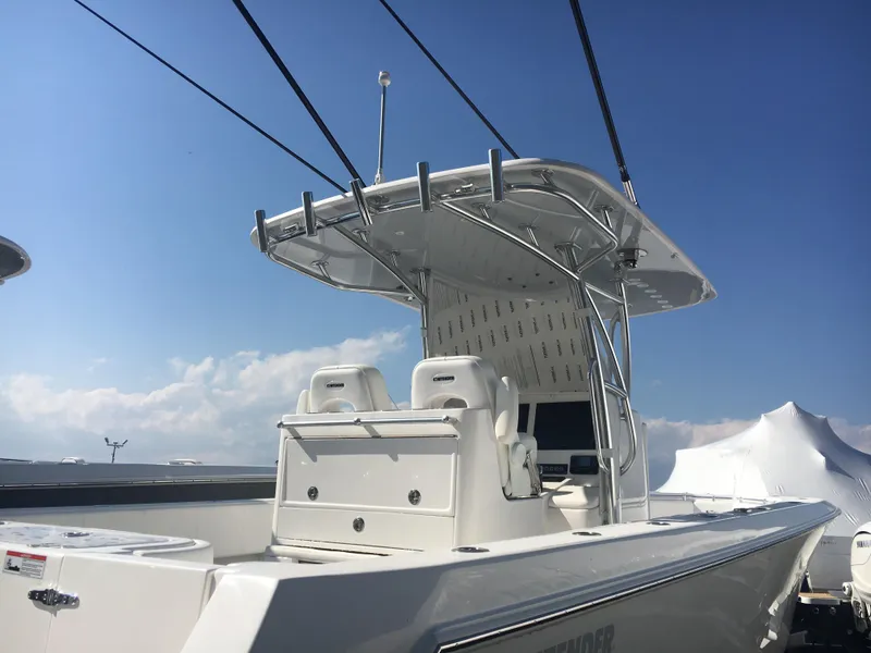 Slide: The Image of 2024 Contender 32 ST boat with dual seats and T-top under a clear sky. - 6