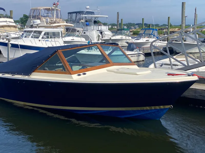 Slide: The Image of 1972 Bertram 25 boat docked in a marina, surrounded by other vessels. - 14