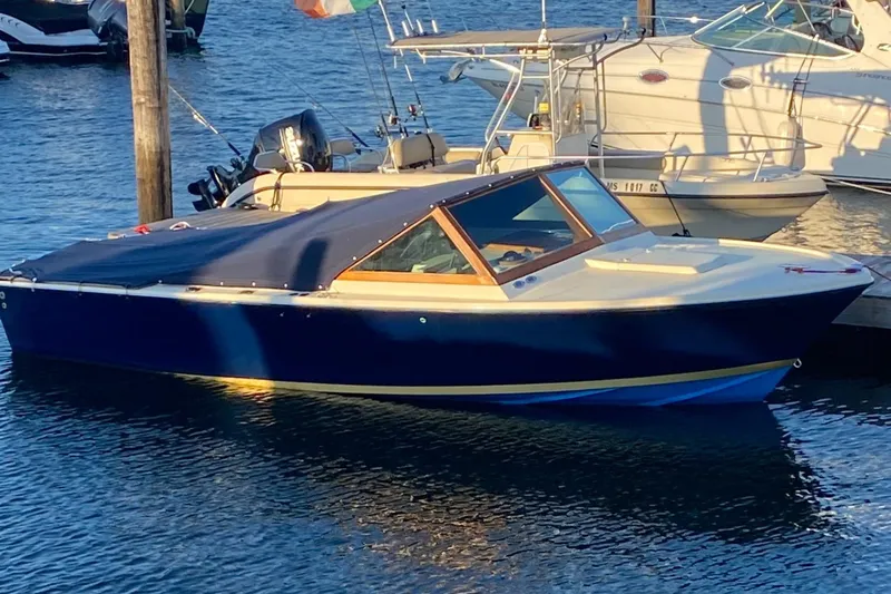 Slide: The Image of 1972 Bertram 25 boat docked in a marina, featuring a sleek blue design. - 4