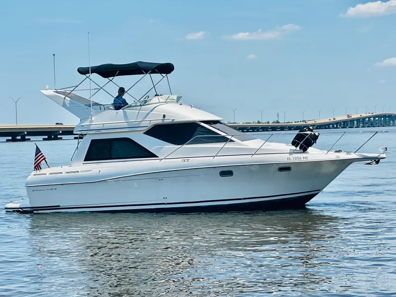 Slide: The Image of 2000 Bayliner 3258 Ciera Command Bridge DX cruising on calm waters. - 2