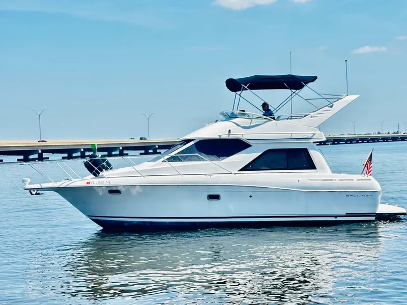 Slide: The Image of 2000 Bayliner 3258 Ciera Command Bridge DX yacht cruising on calm waters. - 3