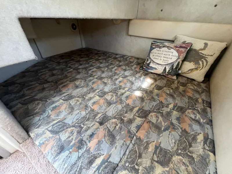 Slide: The Image of 2000 Bayliner 3258 Ciera Command Bridge DX cabin bed with patterned bedding and decorative pillows. - 34