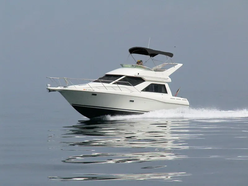 Slide: The Image of 2000 Bayliner 3258 Ciera Command Bridge DX cruising on calm water. - 5
