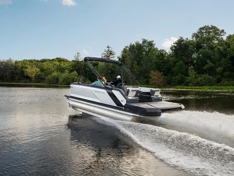 The Image of 2024 Manitou Cruise 22 Bench Tritoon cruising on a lake. - 1
