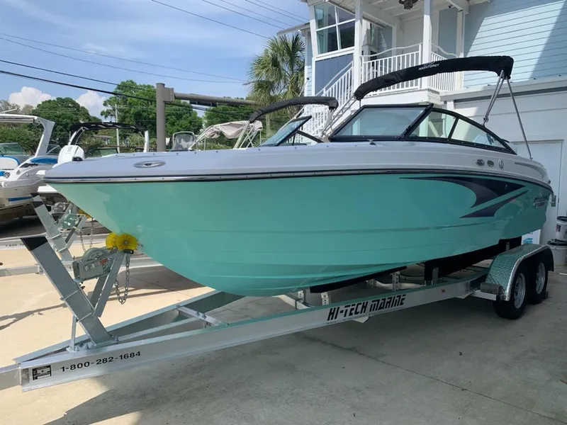 Slide: The Image of 2024 Monterey M-225 boat on a trailer outside a marina. - 0