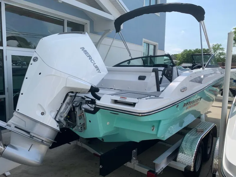 Slide: The Image of 2024 Monterey M-225 boat with Mercury outboard engine, teal hull, and black bimini top. - 1
