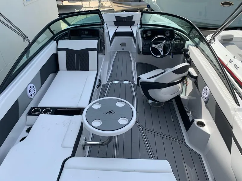 Slide: The Image of 2024 Monterey M-225 boat interior with seating, steering wheel, and table. - 4