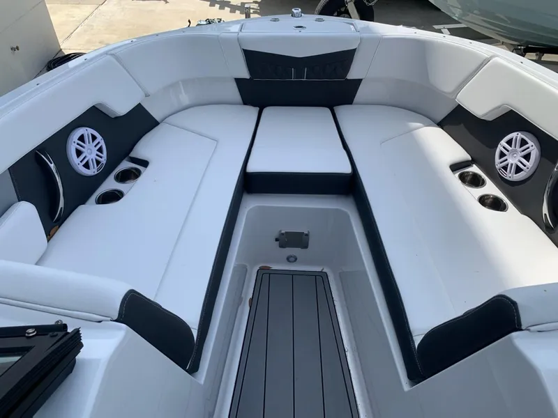 Slide: The Image of 2024 Monterey M-225 boat interior with white and black seating, cup holders, and speakers. - 7