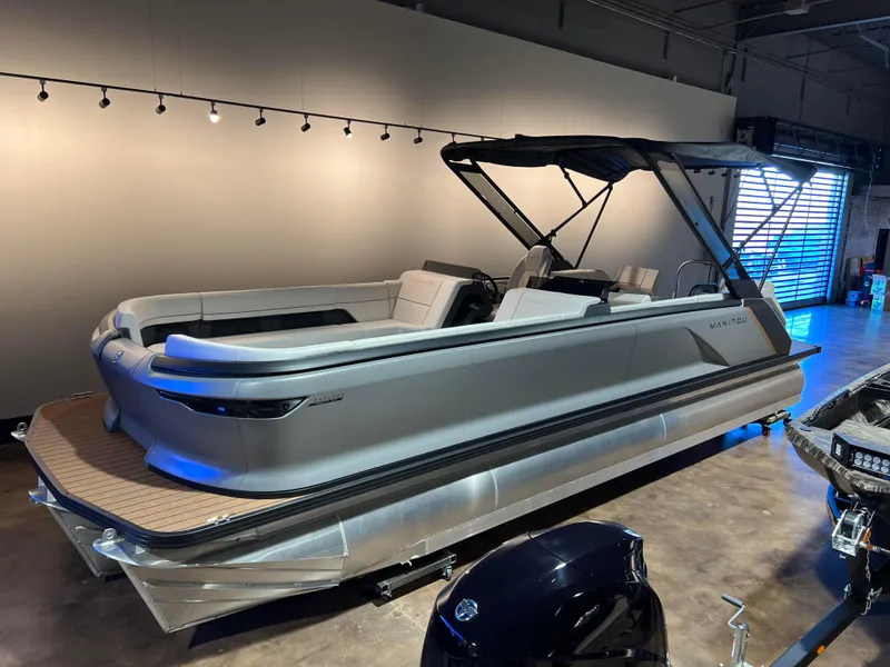 Slide: The Image of 2024 Manitou EXPLORE 26 SWITCHBACK pontoon boat in showroom, sleek design, single engine. - 3
