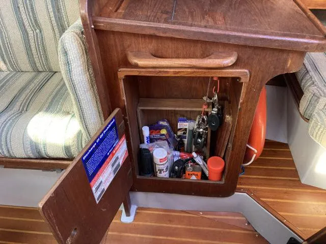 Slide: The Image of Open storage cabinet on a 1980 Sceptre 36 boat with various tools and supplies. - 11