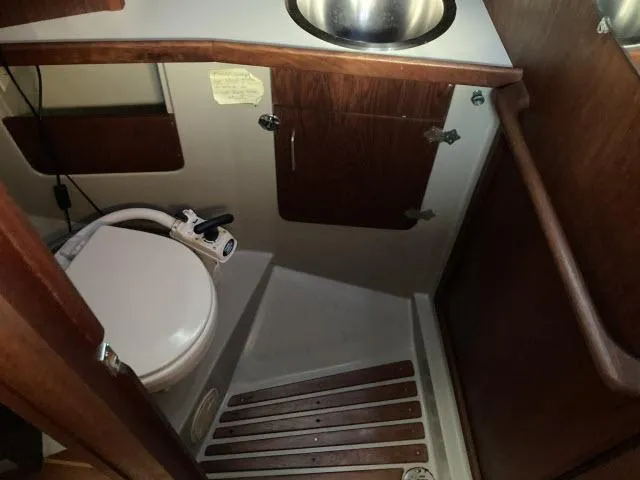 Slide: The Image of 1980 Sceptre 36 boat bathroom with toilet, sink, and wooden cabinetry. - 17