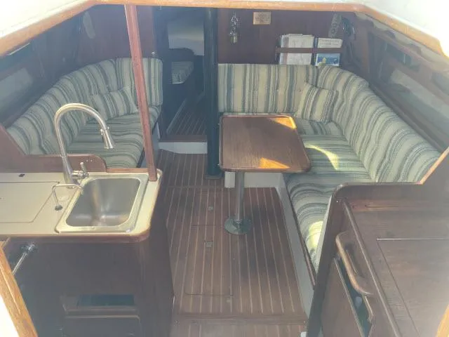 Slide: The Image of Interior of a 1980 Sceptre 36 sailboat with striped seating and compact kitchen. - 2