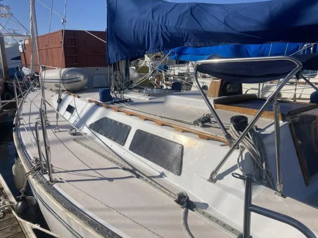 Slide: The Image of 1980 Sceptre 36 sailboat with blue canopy docked at marina. - 34