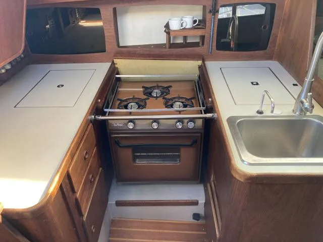 Slide: The Image of 1980 Sceptre 36 boat kitchen with stove, sink, and wooden cabinets. - 5