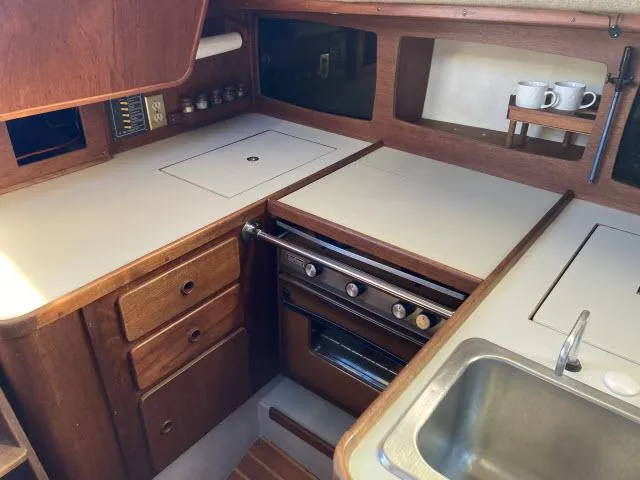 Slide: The Image of 1980 Sceptre 36 boat kitchen with stove, sink, and wooden cabinets. - 6