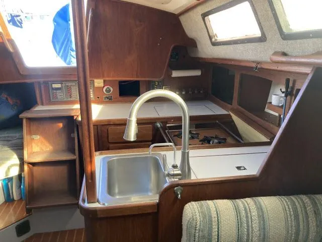 Slide: The Image of 1980 Sceptre 36 sailboat interior with kitchen sink, stove, and wooden cabinetry. - 9