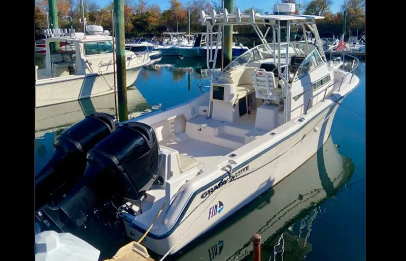 Slide: The Image of 1999 Grady-White 268 Islander boat docked with twin outboard motors. - 0