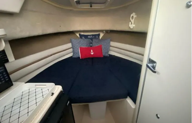 Slide: The Image of 1999 Grady-White 268 Islander cabin interior with bed and nautical-themed pillows. - 4