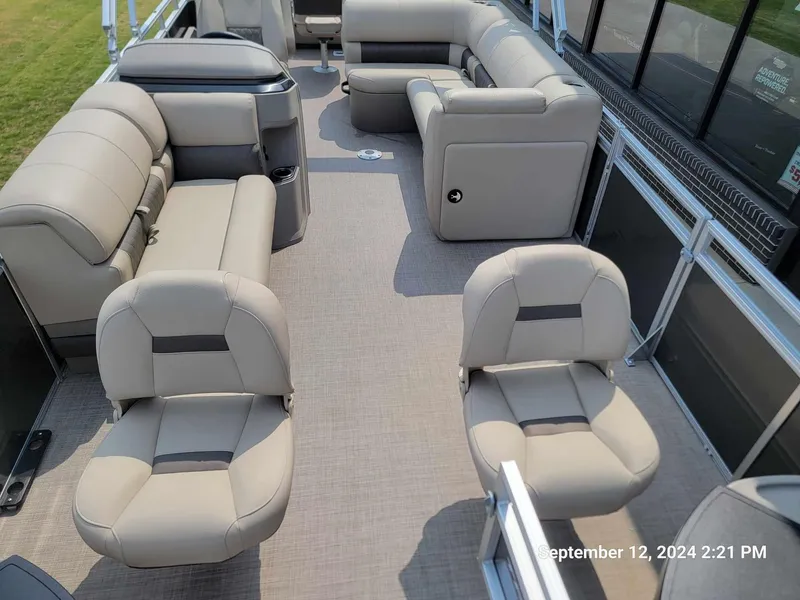Slide: The Image of 2024 Sun Tracker Fishin' Barge 22 DLX interior with beige seating and spacious layout. - 12