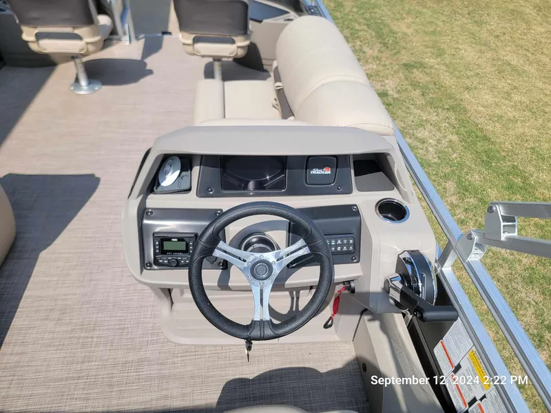 Slide: The Image of 2024 Sun Tracker Fishin' Barge 22 DLX helm with steering wheel and controls. - 5