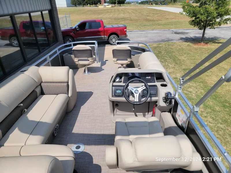 Slide: The Image of 2024 Sun Tracker Fishin' Barge 22 DLX pontoon boat interior with seating and steering console. - 7