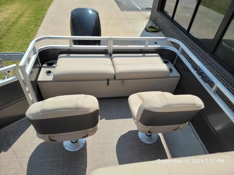 Slide: The Image of 2024 Sun Tracker Fishin' Barge 22 DLX interior with seating and motor view. - 9