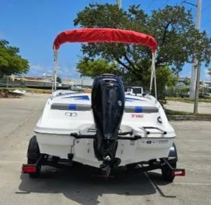 Slide: The Image of 2024 Tahoe T16 boat with red canopy and outboard motor on trailer. - 4