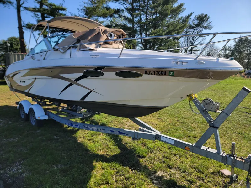 Slide: The Image of 1998 Sea Ray 260 Overnighter boat on a trailer in a grassy area. - 3
