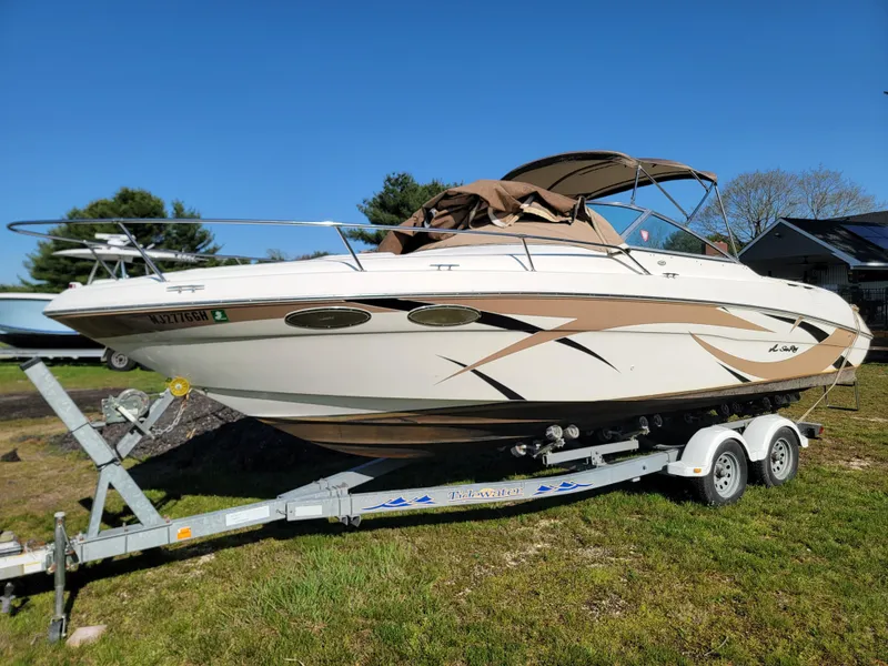 Slide: The Image of 1998 Sea Ray 260 Overnighter boat on a trailer in a grassy area. - 4