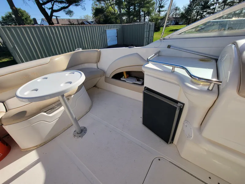 Slide: The Image of 1998 Sea Ray 260 Overnighter boat interior with seating, table, and mini-fridge. - 8