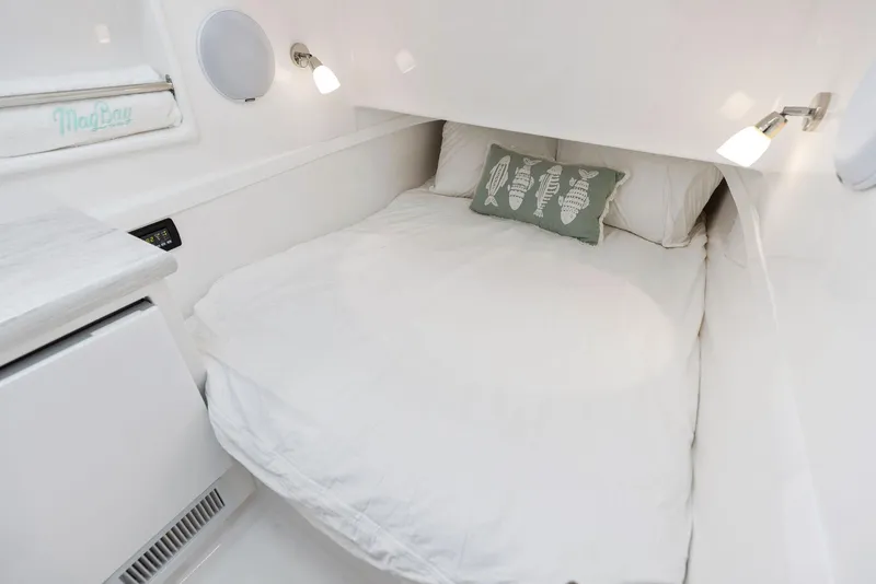 Slide: The Image of Cozy cabin bed in 2025 Mag Bay 43 CC boat with white bedding and seashell pillow. - 42