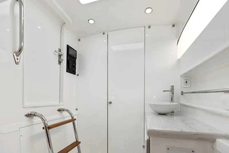 Slide: The Image of 2025 Mag Bay 43 CC boat interior with modern bathroom and wooden ladder. - 45