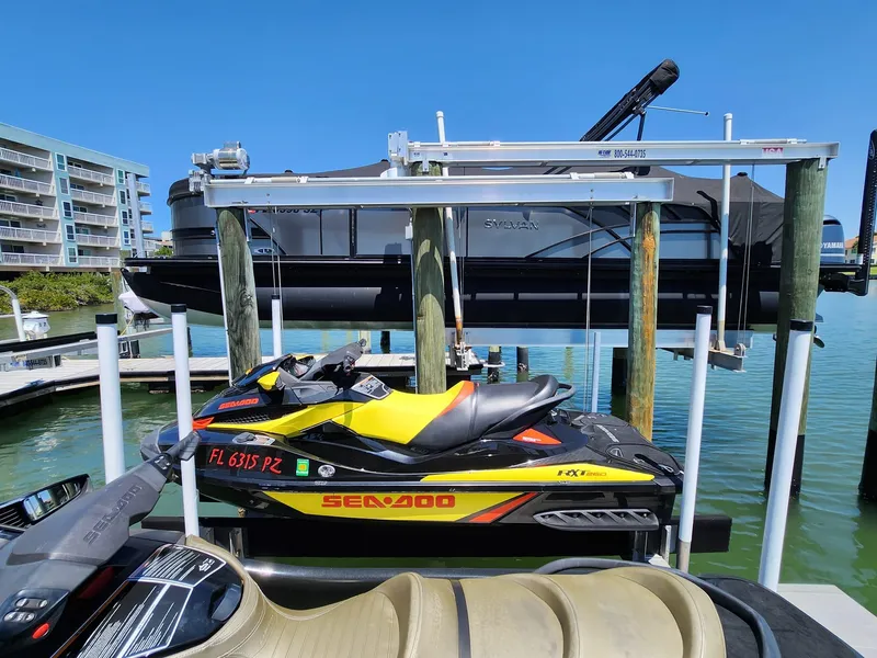 Slide: The Image of 2015 Sea-Doo RXT 260 jet ski on a lift at a marina. - 2