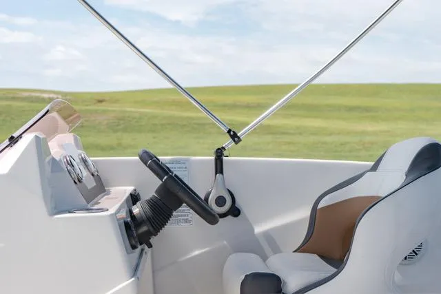 Slide: The Image of 2022 Starcraft SVX 171 OB boat interior with steering wheel and captain's chair. - 8