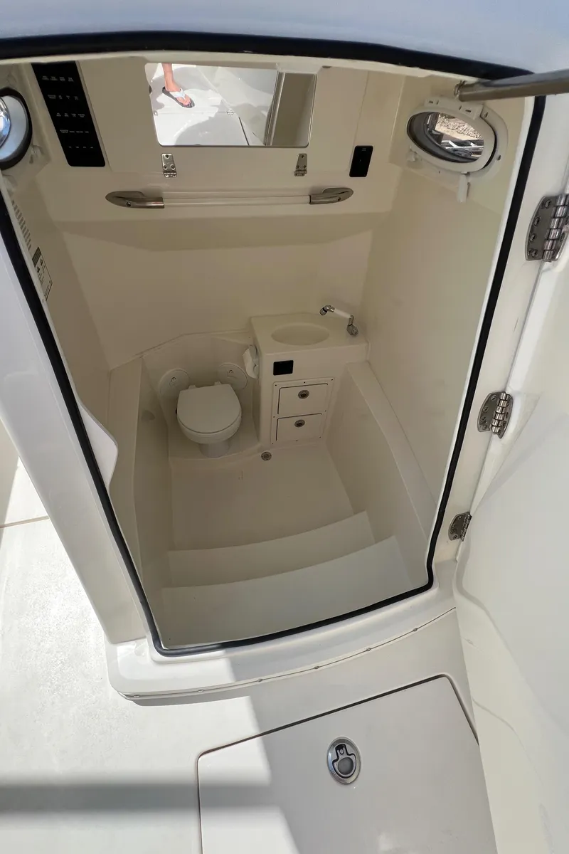 Slide: The Image of 2024 Cobia 301 Center Console interior cabin with toilet and sink. - 14
