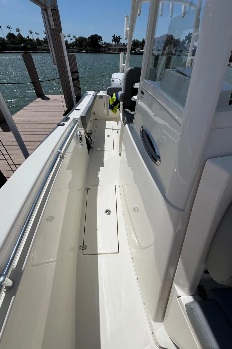 Slide: The Image of 2024 Cobia 301 Center Console boat docked by the water. - 15