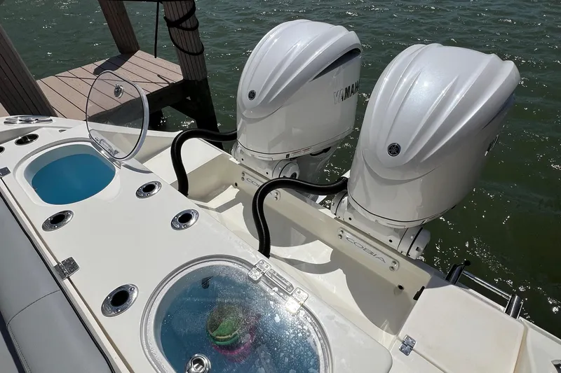 Slide: The Image of 2024 Cobia 301 Center Console with twin outboard engines on the water. - 17