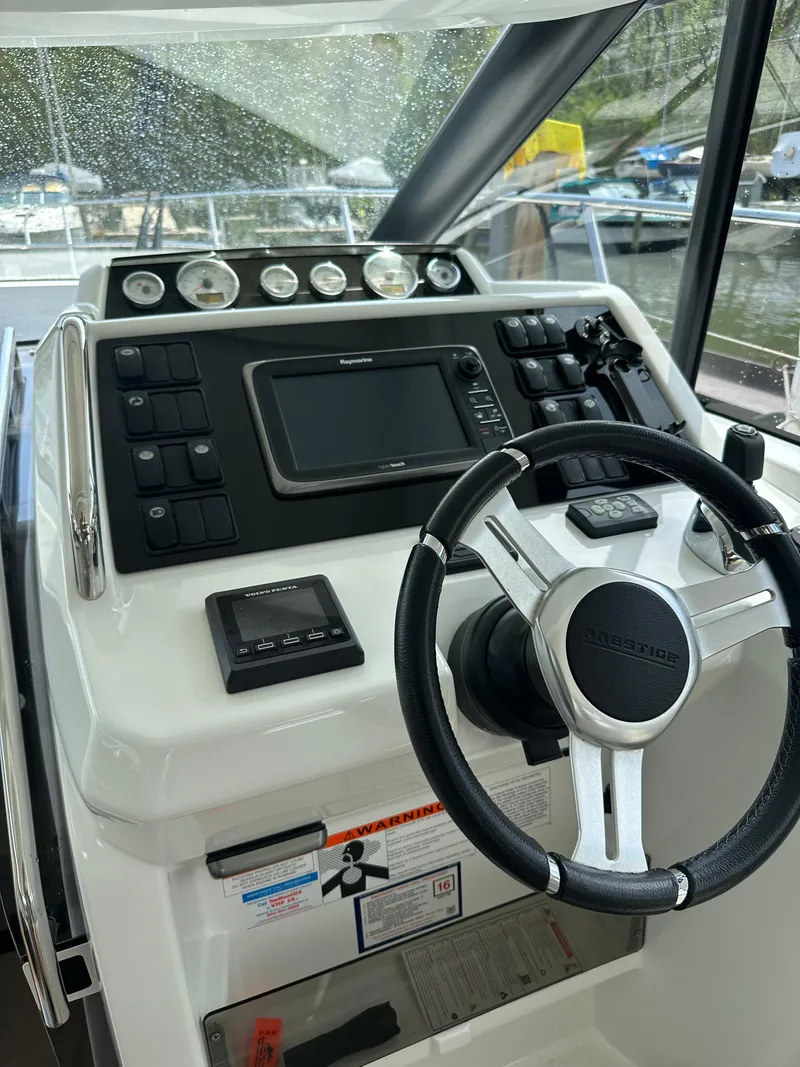 Slide: The Image of 2016 Jeanneau Leader 36 helm station with steering wheel and navigation controls. - 32