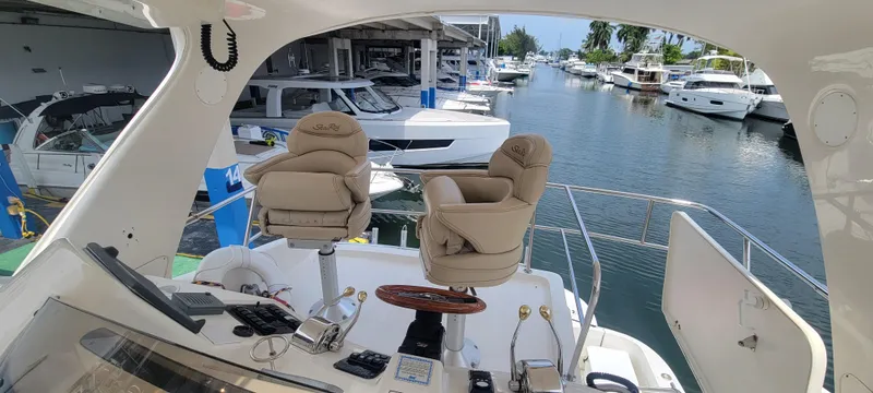 Slide: The Image of 2004 Sea Ray 480 Sedan Bridge yacht helm with marina view. - 14