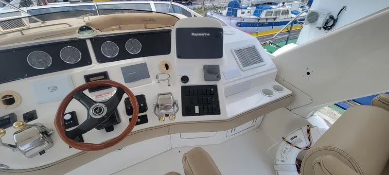 Slide: The Image of 2004 Sea Ray 480 Sedan Bridge helm with steering wheel and navigation controls. - 17