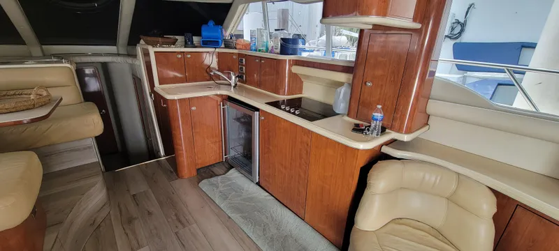 Slide: The Image of Interior of 2004 Sea Ray 480 Sedan Bridge yacht with kitchen and seating area. - 20