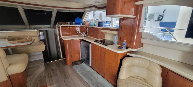 Slide: The Image of Interior of 2004 Sea Ray 480 Sedan Bridge yacht with kitchen and seating area. - 21