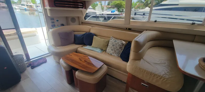 Slide: The Image of Luxurious interior of a 2004 Sea Ray 480 Sedan Bridge yacht with plush seating and wooden table. - 23