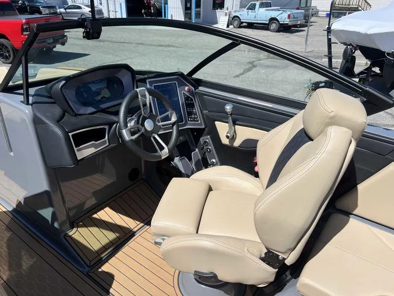 Slide: The Image of 2023 MasterCraft XT24 boat interior with beige seats and modern dashboard. - 10