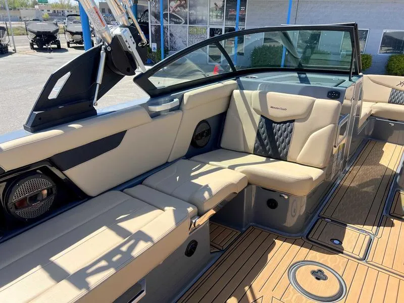 Slide: The Image of 2023 MasterCraft XT24 boat interior with beige seating and modern design. - 11