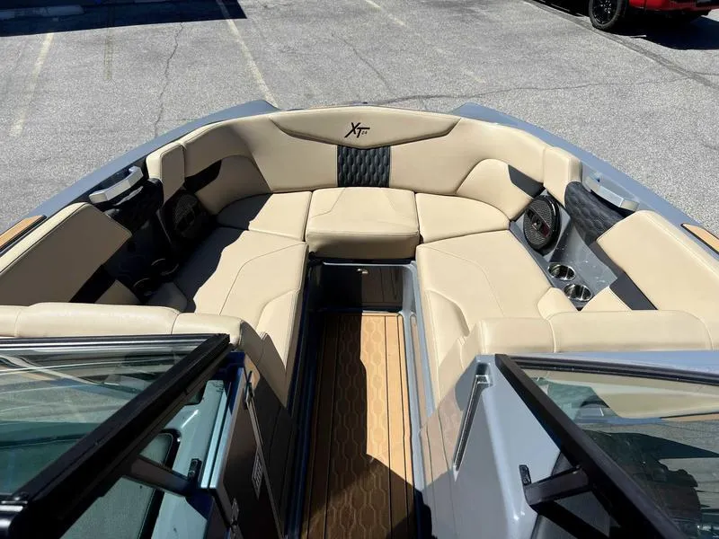 Slide: The Image of 2023 MasterCraft XT24 boat interior with beige seating and modern design. - 13
