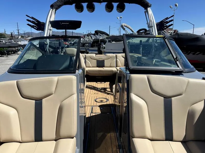 Slide: The Image of 2023 MasterCraft XT24 boat interior with beige seating and open windshield. - 14