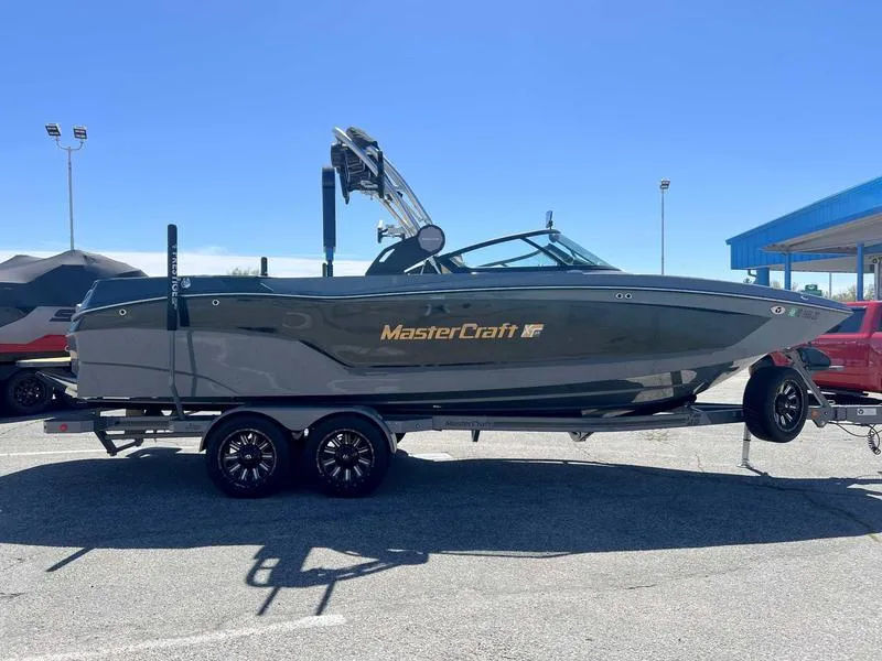 Slide: The Image of 2023 MasterCraft XT24 boat on a trailer in a parking lot. - 5