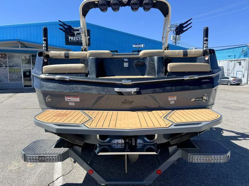 Slide: The Image of 2023 MasterCraft XT24 boat rear view with teak swim platform. - 6
