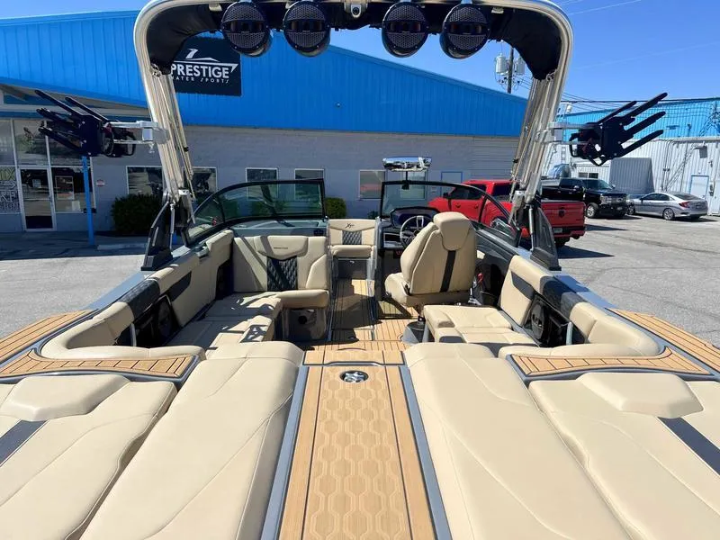 Slide: The Image of 2023 MasterCraft XT24 boat interior with beige seating and teak flooring. - 8